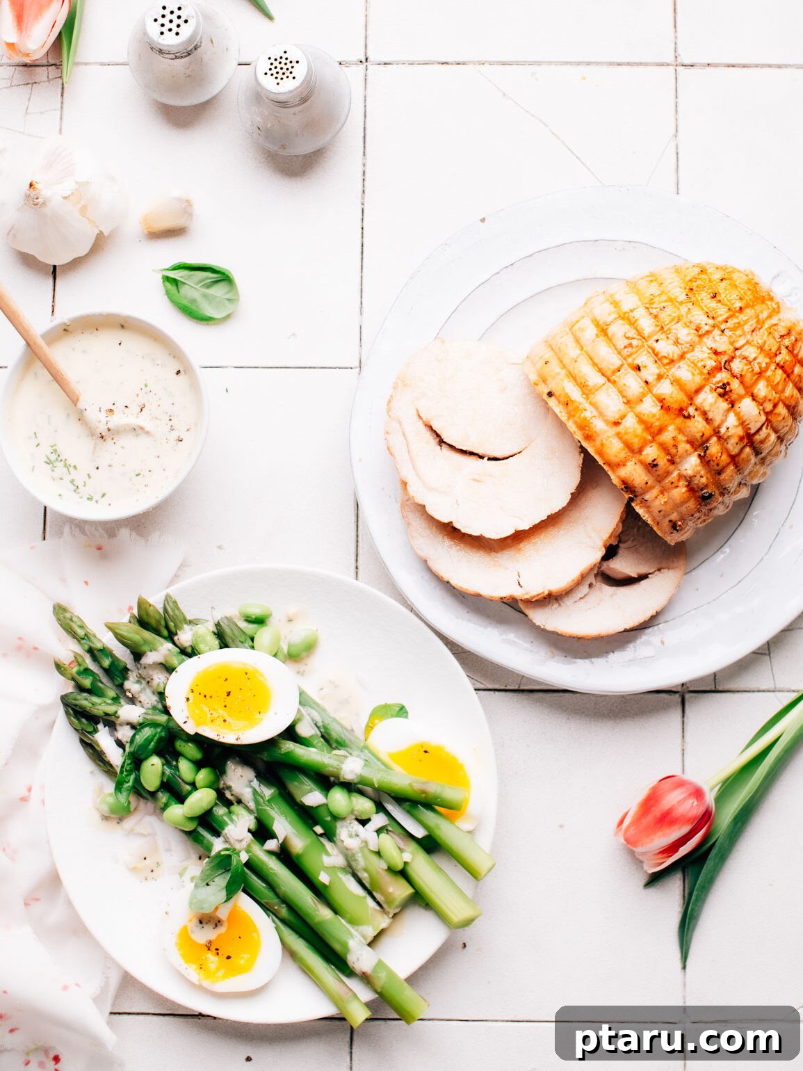 Zesty Lemon Tahini Vinaigrette 5 Lemon tahini dressing drizzled generously over roasted asparagus and slices of turkey roast, presenting a wholesome meal.