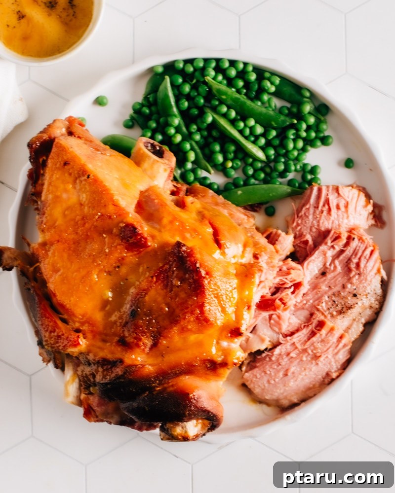 Over 60 Irresistible Recipes for Your Easter Feast 12 Juicy Pressure Cooker Ham served on a plate with fresh green vegetables.