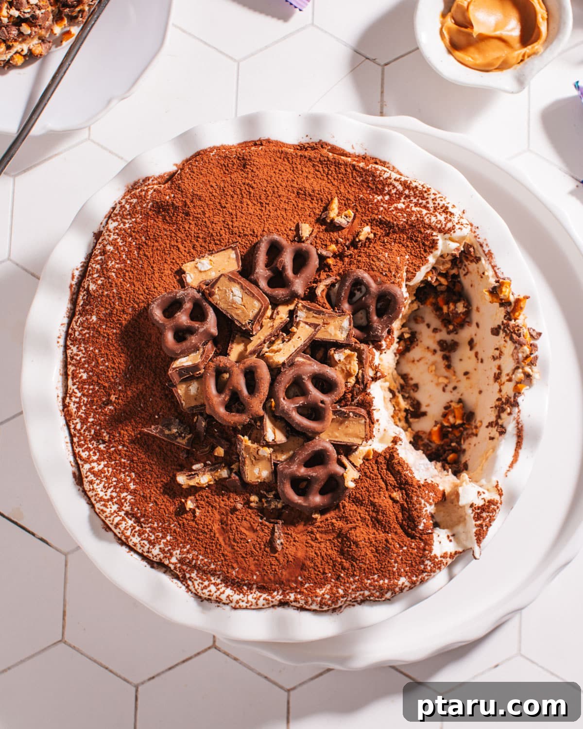 Over 60 Irresistible Recipes for Your Easter Feast 47 Peanut Butter Pretzel Pie with a scoop removed, showcasing its creamy filling and crunchy crust.