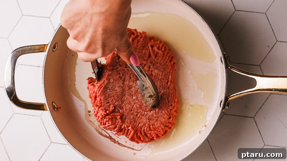 Sauce Simmered Pasta Perfection 4 Ground beef searing in a hot skillet, developing a golden-brown crust.