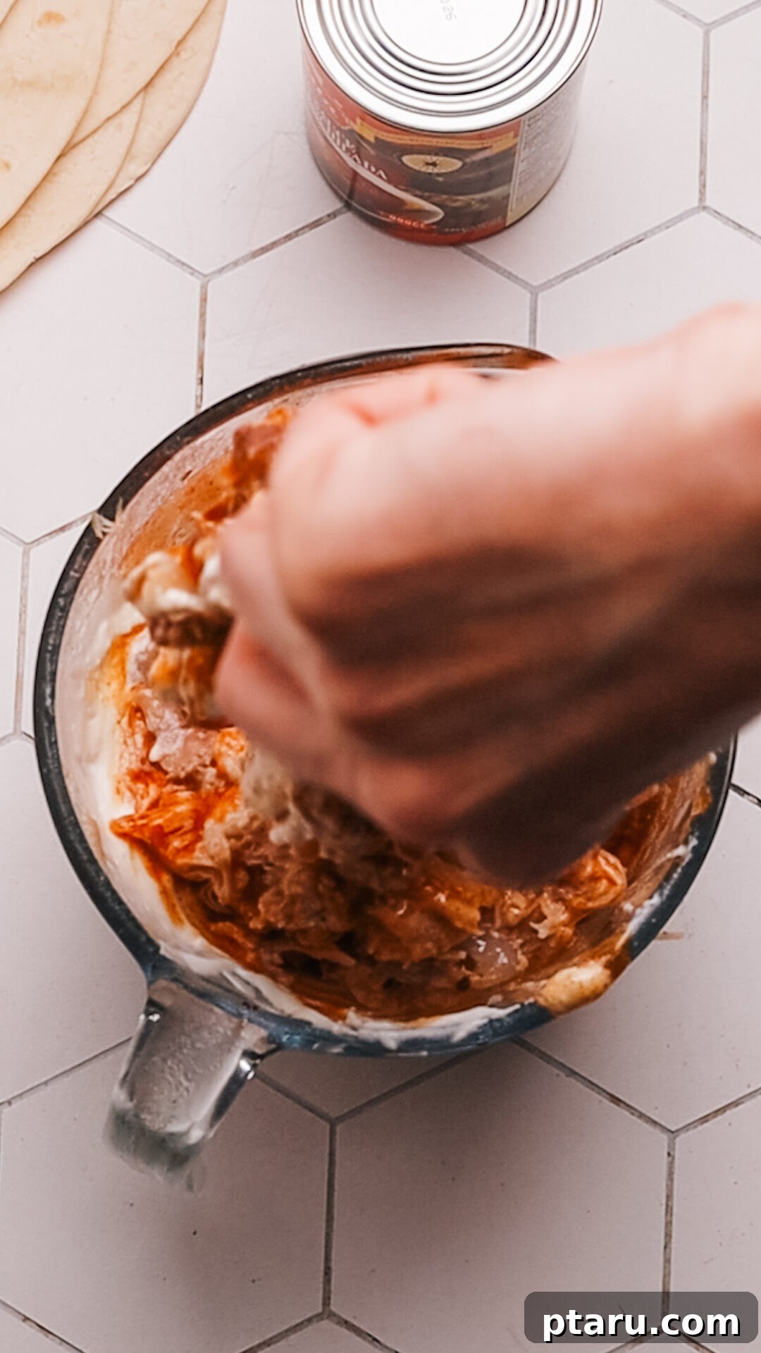 Cheesy Chicken Enchilada Bake 5 Step 2: Spreading the initial layer of enchilada sauce in the baking dish.