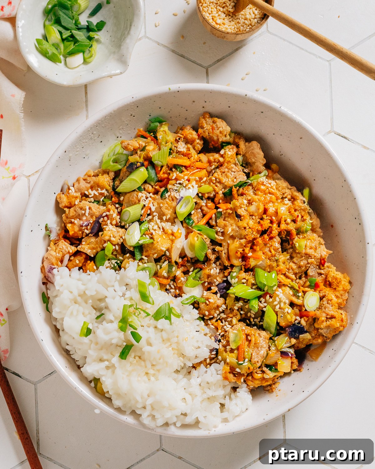 Quick Fix Egg Roll Bowl 2 Egg roll in a bowl recipe served with rice, garnished with green onions and sesame seeds.