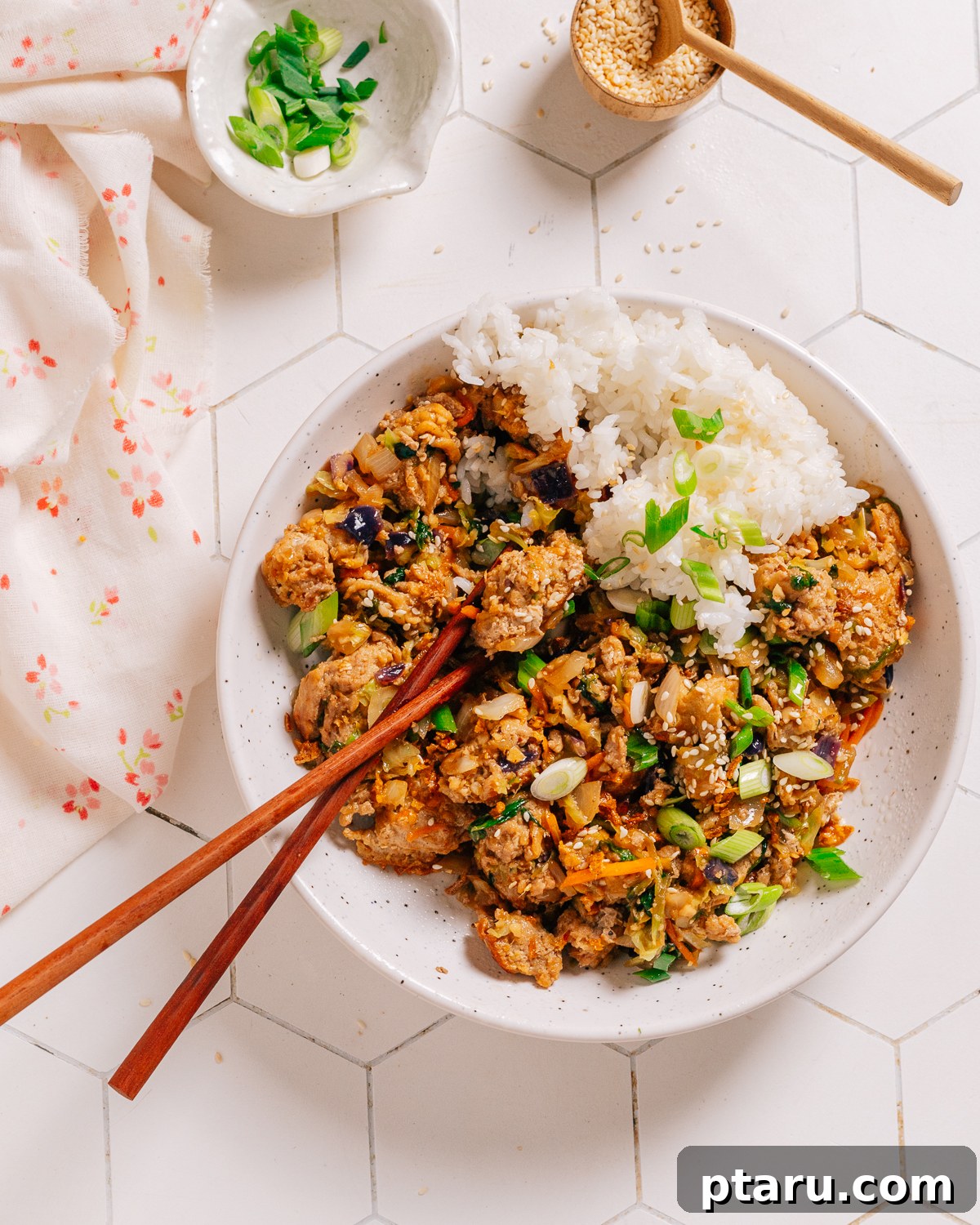 Quick Fix Egg Roll Bowl 11 Egg roll in a bowl with chopsticks, garnished with sesame seeds and green onions.