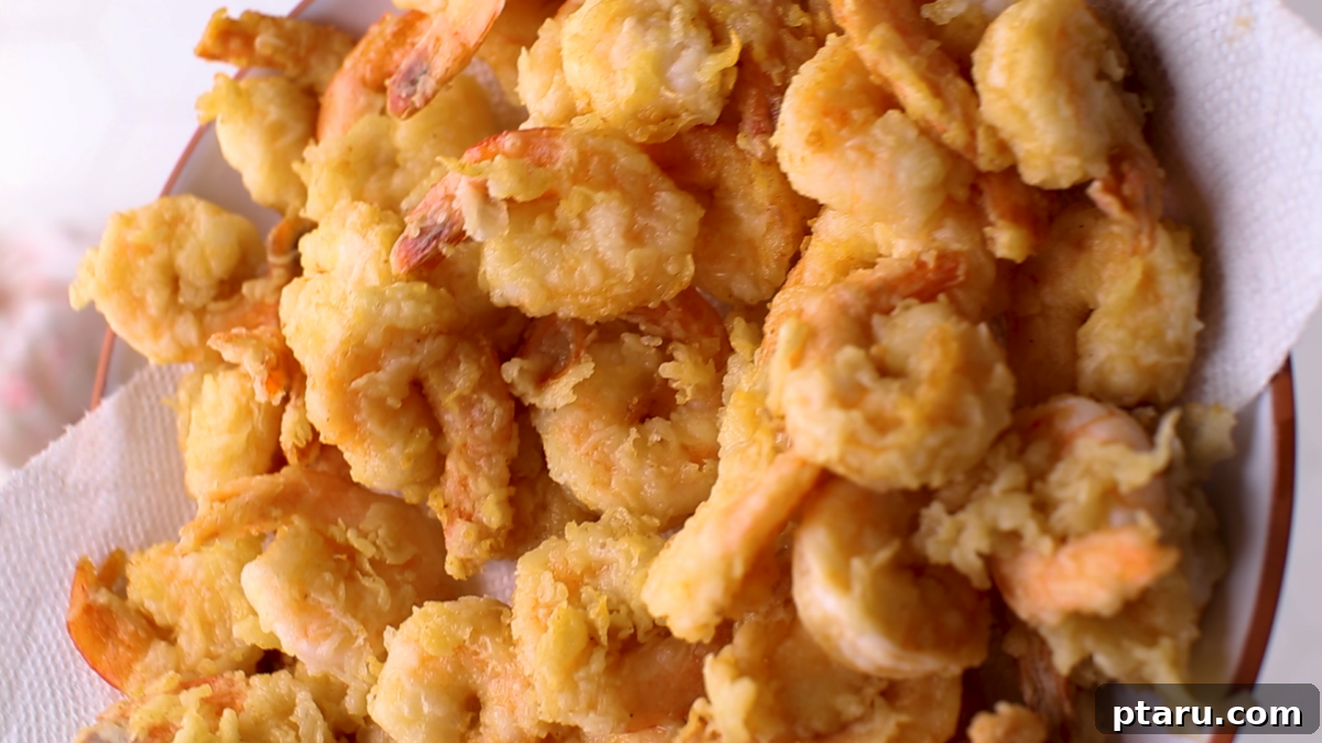 Turn Cooked Shrimp into a Crispy Delight 8 Freshly fried shrimp resting on a wire rack to drain excess oil