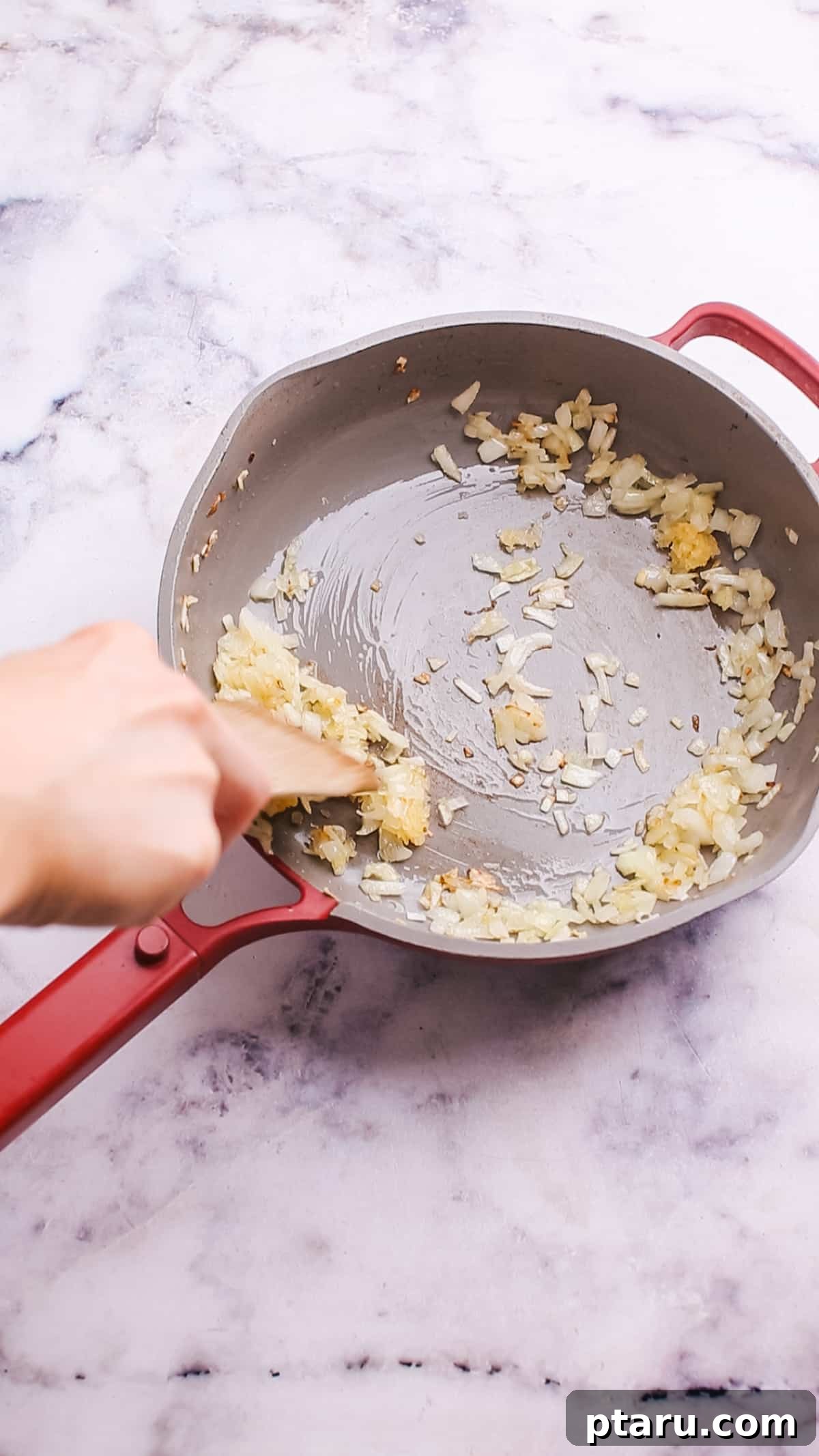 Game-Changing Cauliflower Casserole 4 Sautéing chopped onions and garlic in a saucepan with melted butter, releasing their fragrant aroma.