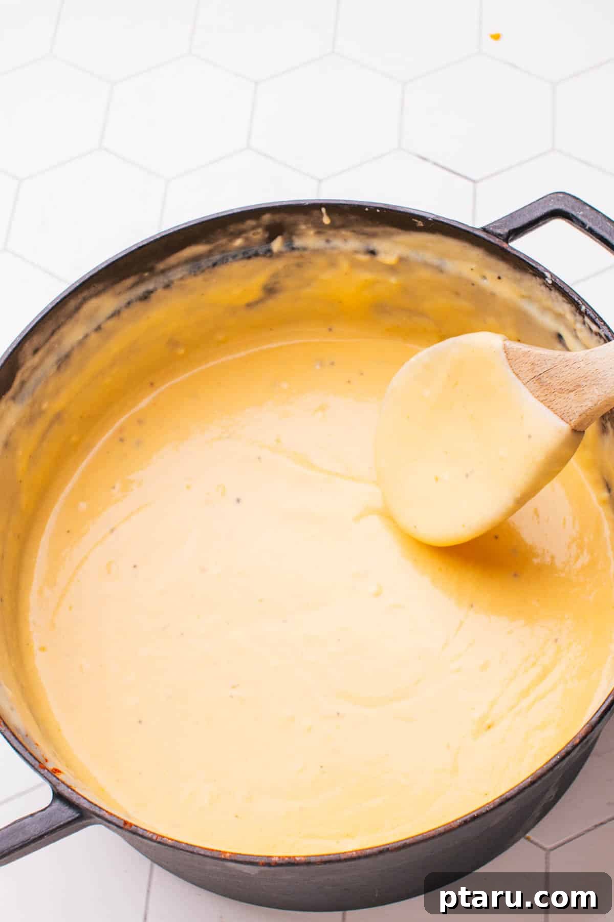 Game-Changing Cauliflower Casserole 6 Freshly cooked cauliflower florets mixed with a rich, creamy cheese sauce, ready to be transferred to a baking dish for casserole.