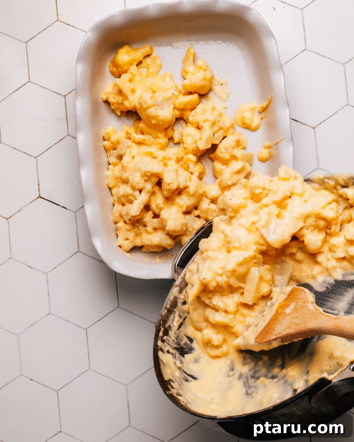 Game-Changing Cauliflower Casserole 8 A mixture of panko breadcrumbs and grated cheddar cheese being sprinkled evenly over a cauliflower casserole in a baking dish.