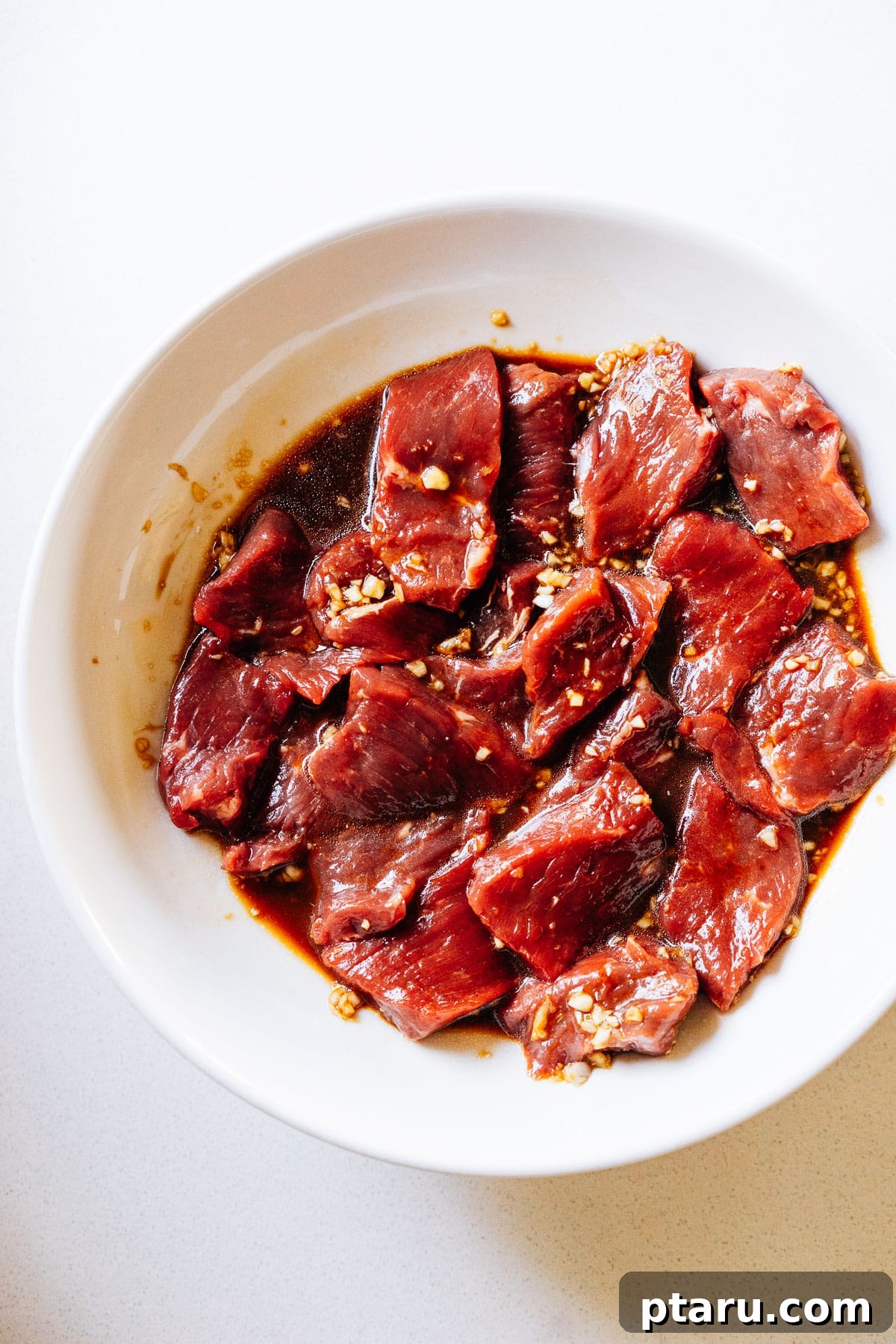 Sweet and Savory Teriyaki Beef 5 Thinly sliced beef marinating in teriyaki sauce in a bowl.