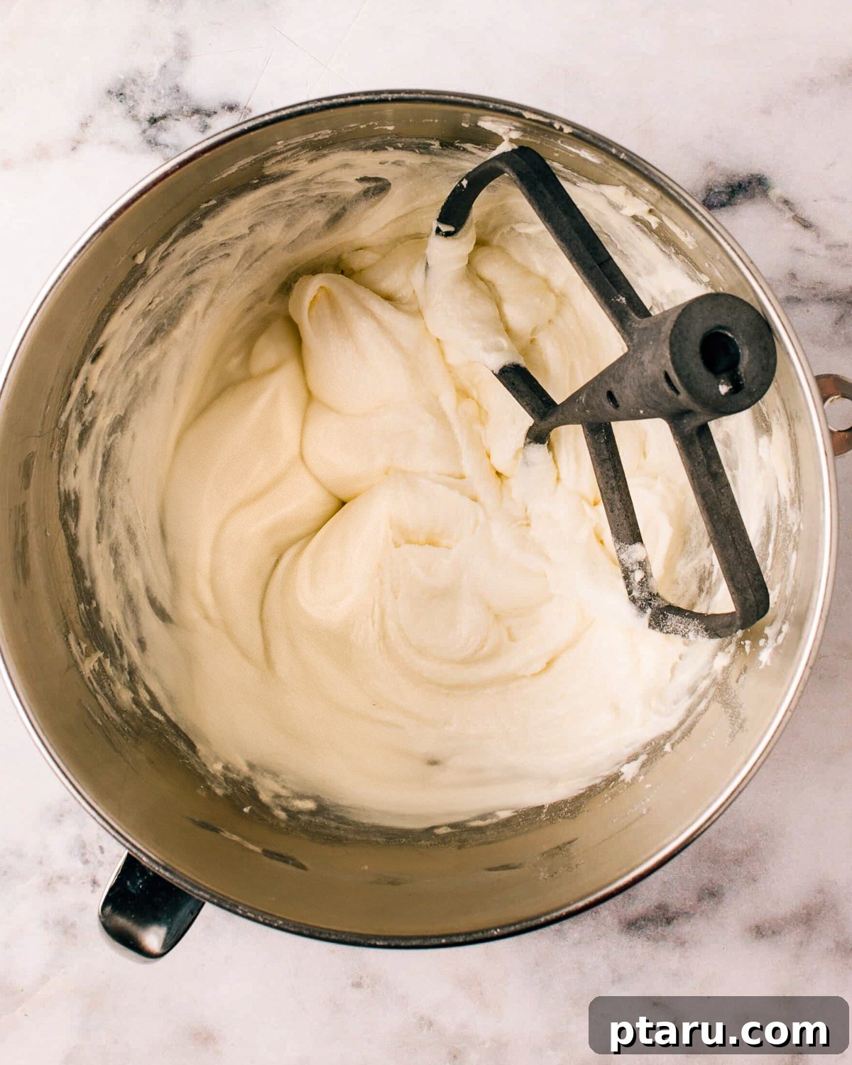 Silky Smooth Cream Cheese Frosting 2 Cream Cheese Icing Recipe in a mixing bowl, showcasing its fluffy texture.