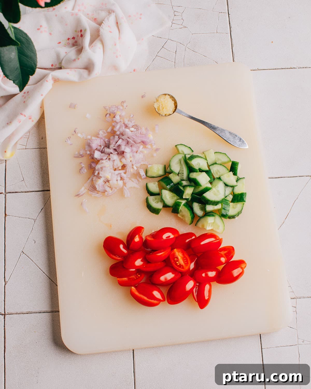 Tuscan Pasta Toss 5 Diced cucumber and halved cherry tomatoes on a cutting board, ready for the pasta salad.