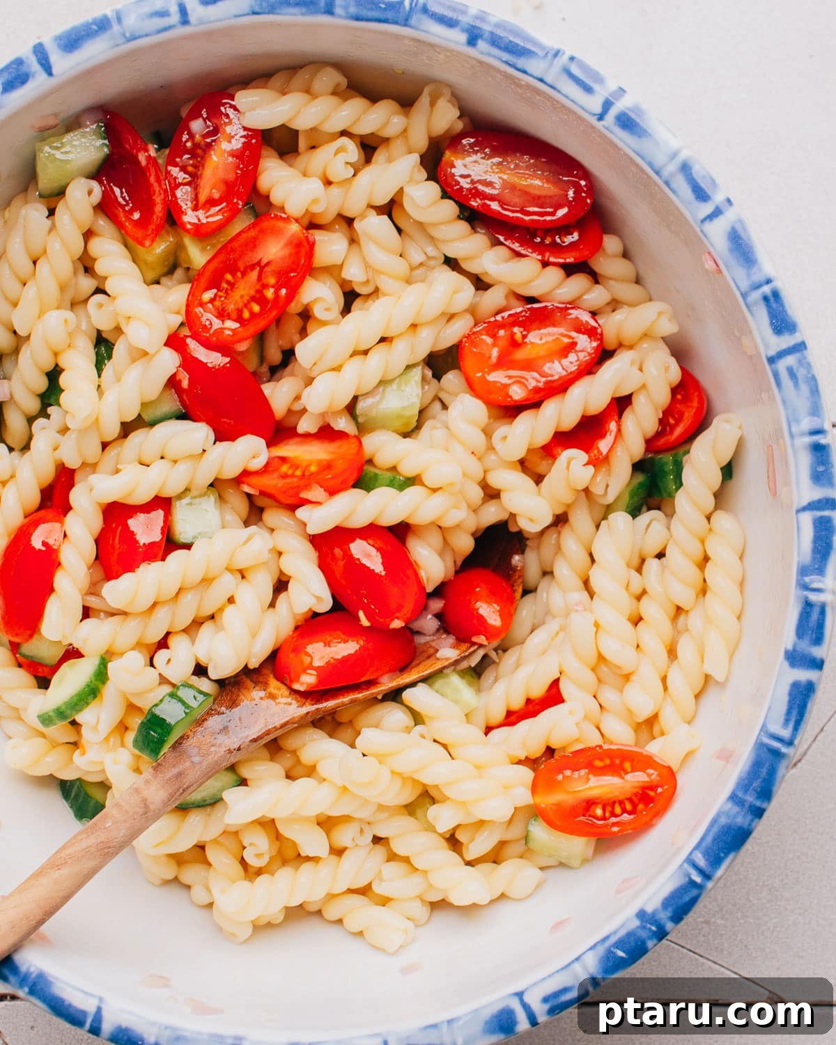 Tuscan Pasta Toss 7 A large bowl of fully tossed Pasta Salad with Italian Dressing, showcasing its vibrant colors and textures.