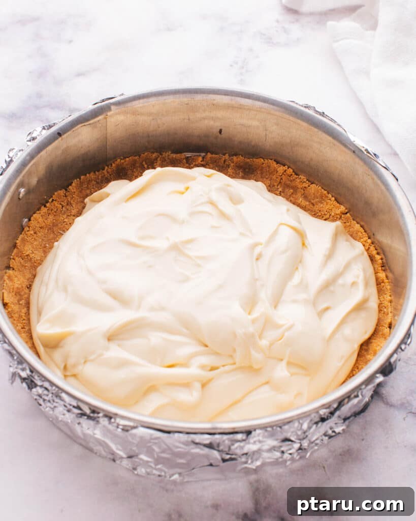 Perfect Graham Cracker Crust 4 Smooth cheesecake batter being poured into a perfectly formed graham cracker crust.