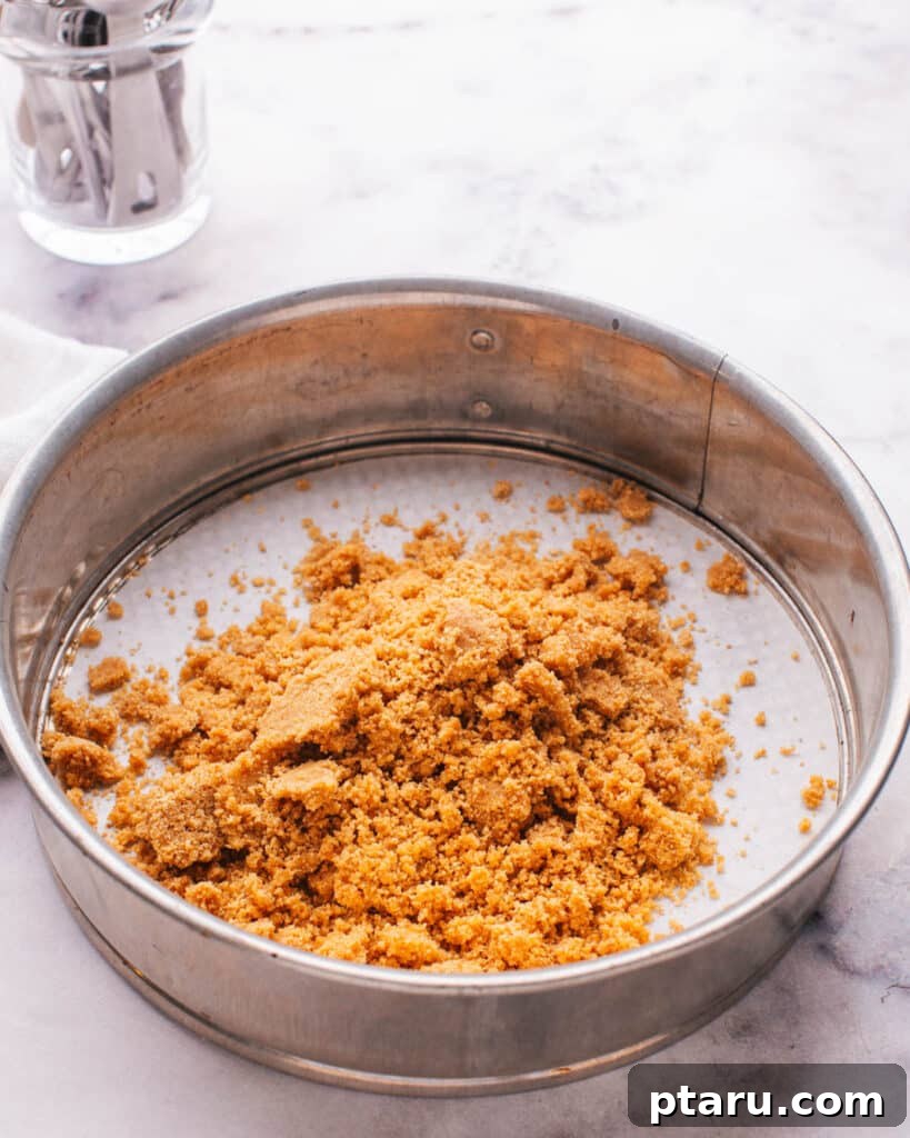 Perfect Graham Cracker Crust 9 Firmly pressing the graham cracker crust into a pan with a measuring cup.