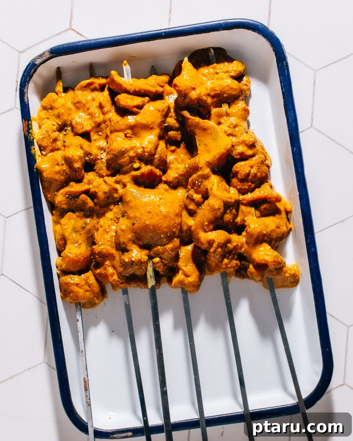 Authentic Thai Satay Skewers 5 Chicken strips marinating in a bowl with Thai satay spices and coconut milk.
