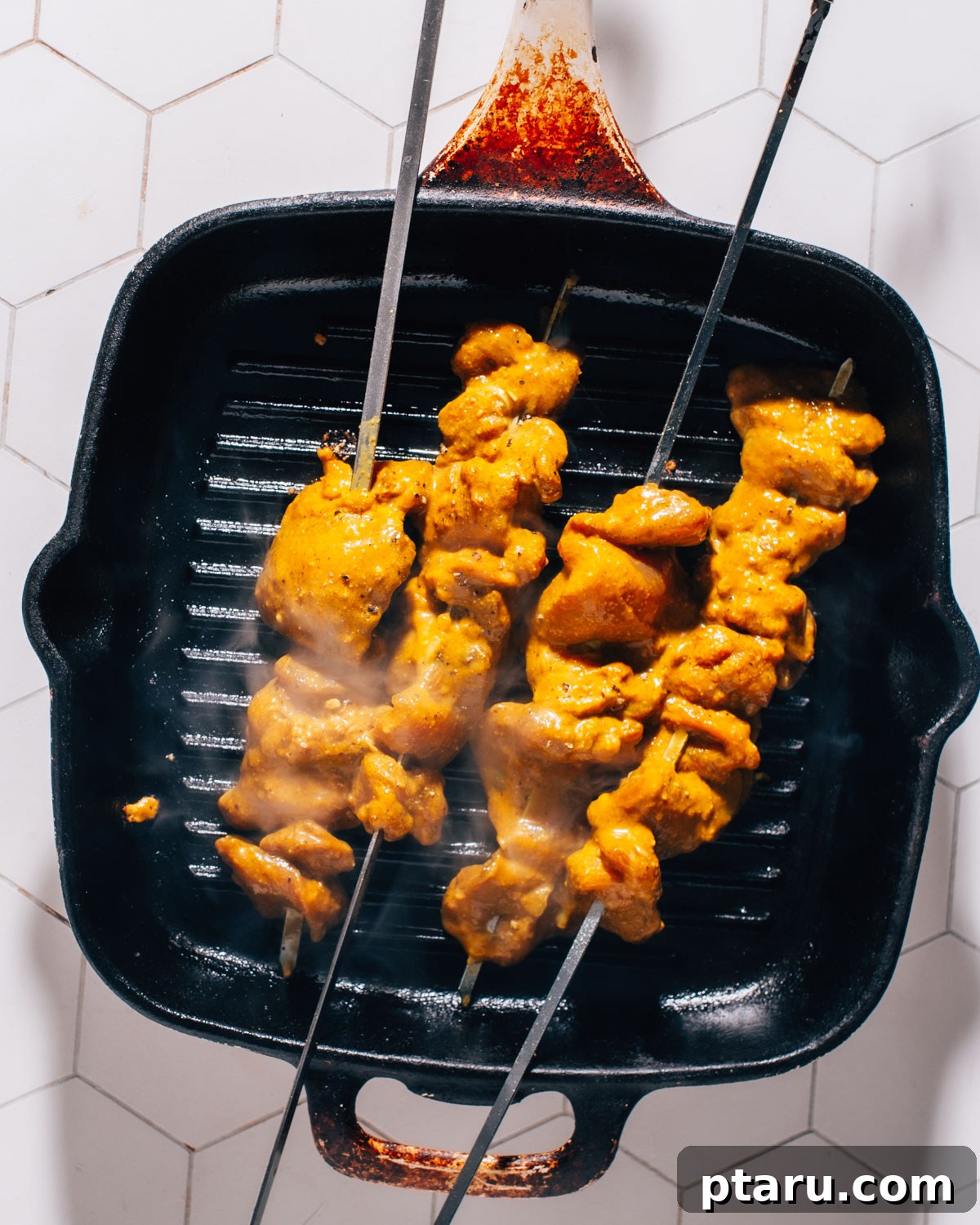 Authentic Thai Satay Skewers 6 Thai Chicken Satay skewers grilling over an open flame, developing a beautiful char.