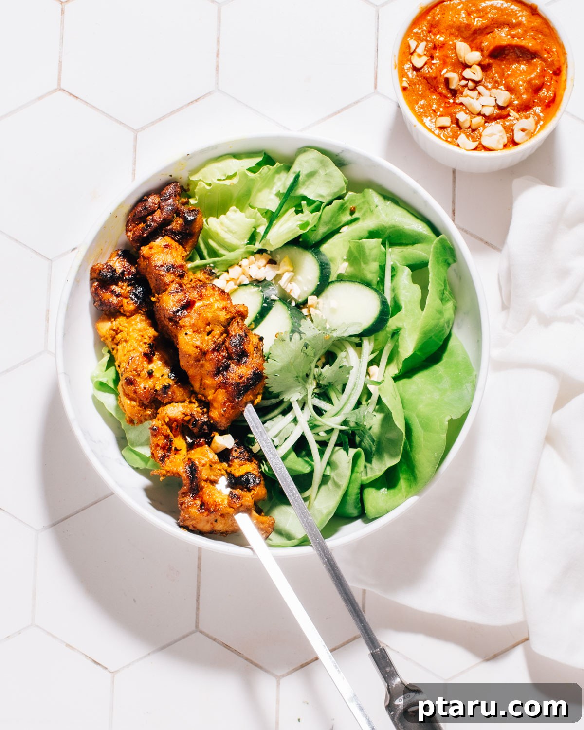 Authentic Thai Satay Skewers 7 Thai Satay skewers beautifully arranged over a bed of fresh green salad, generously drizzled with rich peanut sauce.