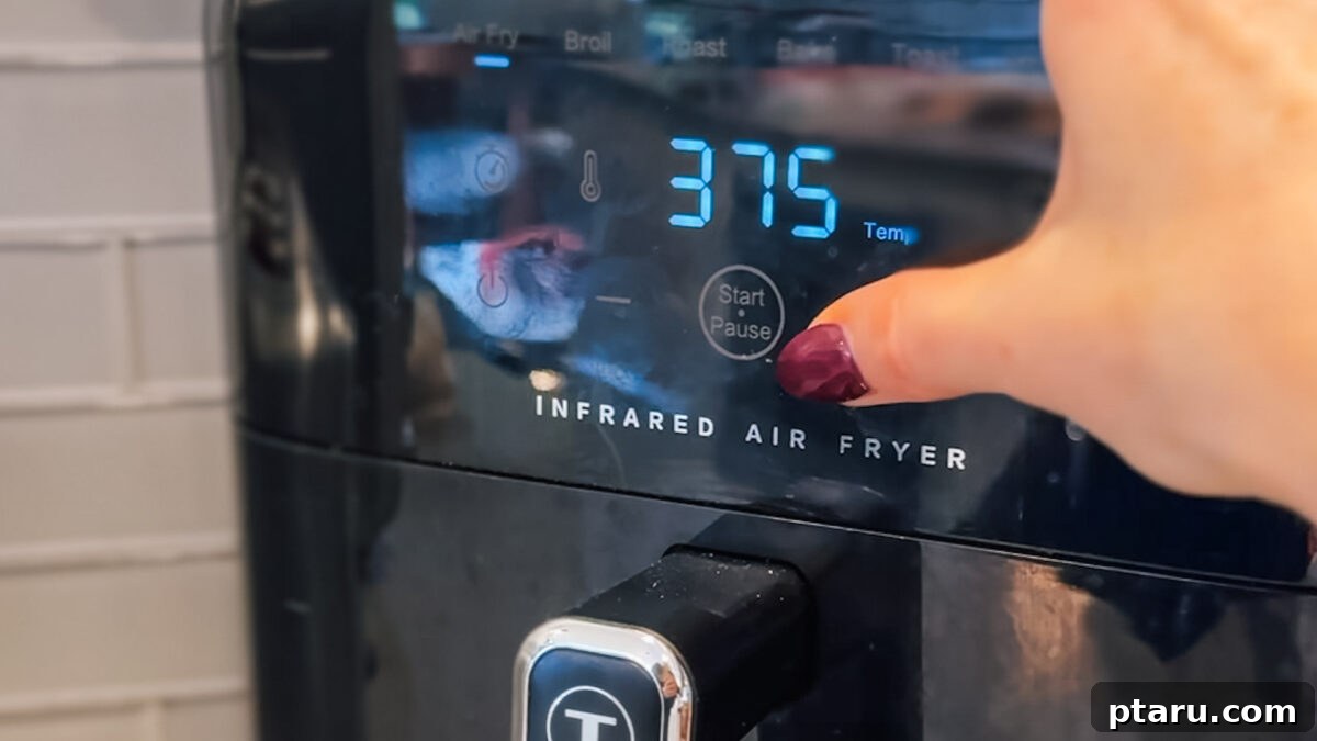 Crispy Air Fryer Quesadillas 4 Hands pressing buttons on an Air Fryer control panel, setting the temperature and time.