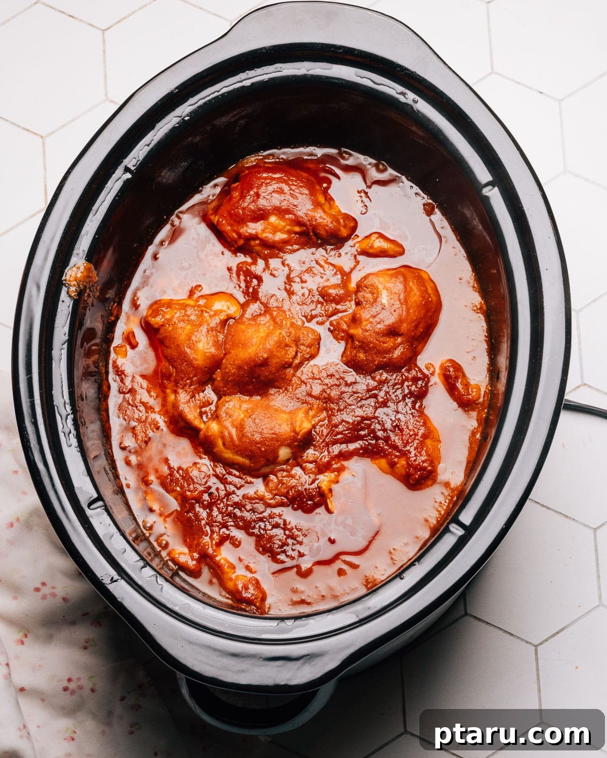 Effortless Slow Cooker BBQ Chicken 8 Cooked chicken being shredded with two forks in the crockpot.