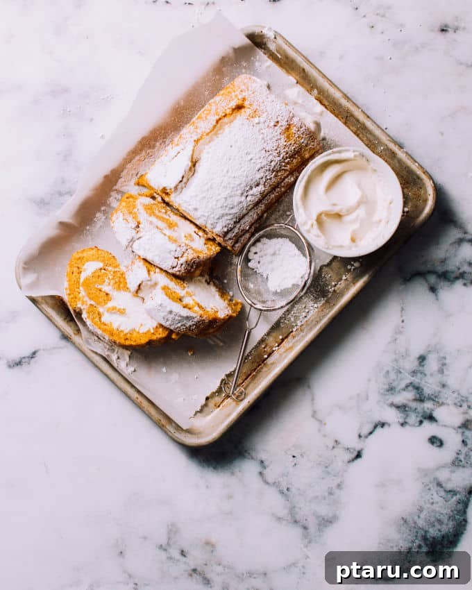 Spiced Pumpkin Swirl Cake 2 Classic Pumpkin Roll Cake with creamy filling and a dusting of confectioners' sugar