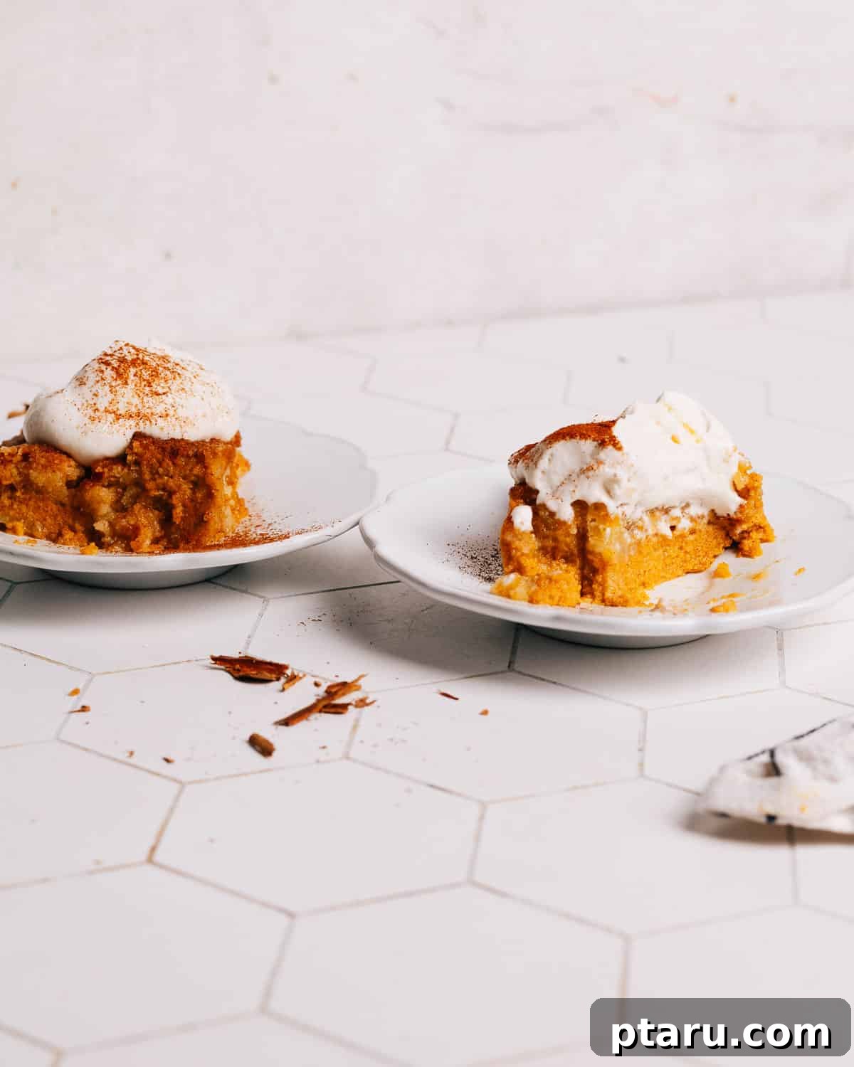 Effortless Autumn Pumpkin Bake 9 Individual slices of Pumpkin Dump Cake presented on elegant plates, garnished with whipped cream and a sprinkle of cinnamon.