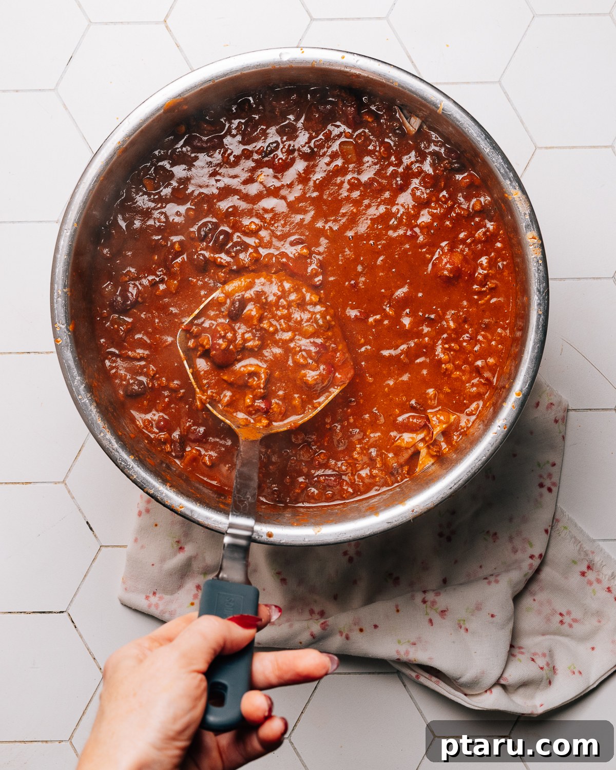 One-Pot Turkey Chili Delight 4 A ladle scooping rich Instant Pot turkey chili from a pot.