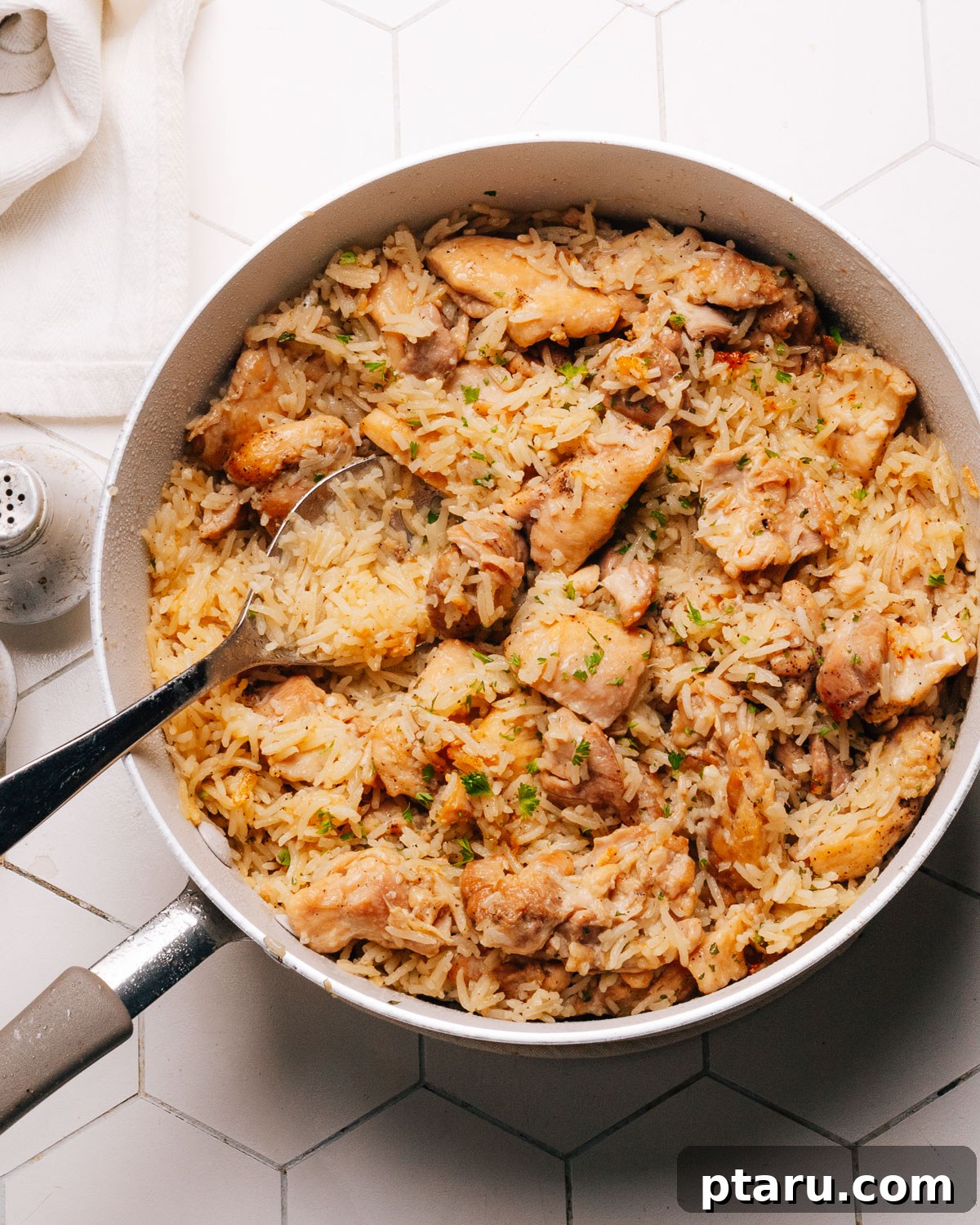 Savory One-Pot Chicken and Rice 2 A large pot filled with a generous serving of perfectly cooked chicken and rice, garnished with fresh herbs.