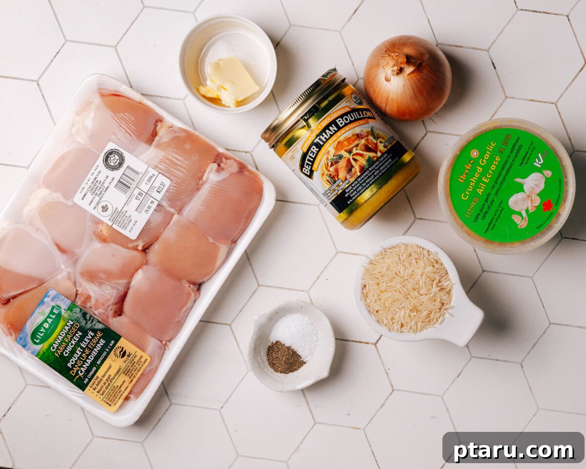 Savory One-Pot Chicken and Rice 3 A selection of fresh ingredients laid out on a cutting board, including chicken thighs, onion, garlic, and rice.