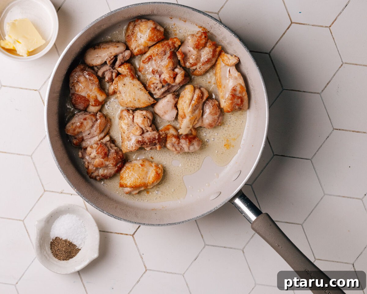 Savory One-Pot Chicken and Rice 4 Raw chicken pieces seasoned with salt and pepper in a hot skillet, ready for searing.