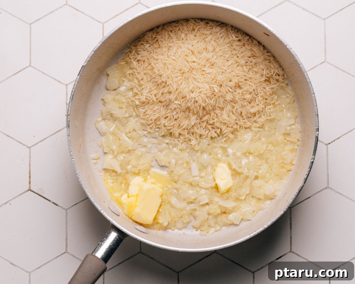 Savory One-Pot Chicken and Rice 6 Uncooked long-grain white rice being toasted in melted butter within the skillet.