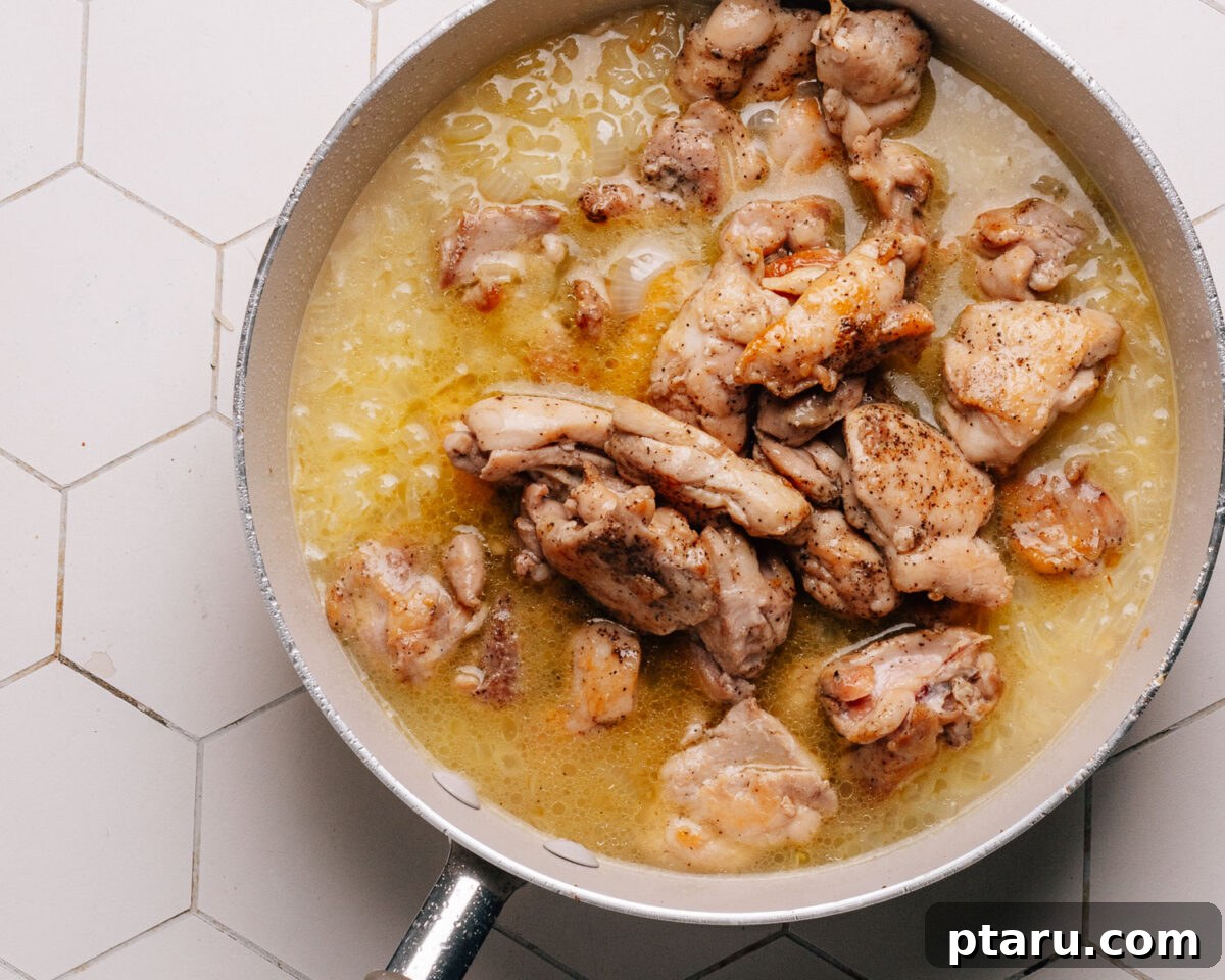 Savory One-Pot Chicken and Rice 8 A skillet covered with a lid, symbolizing the simmering process of chicken and rice.