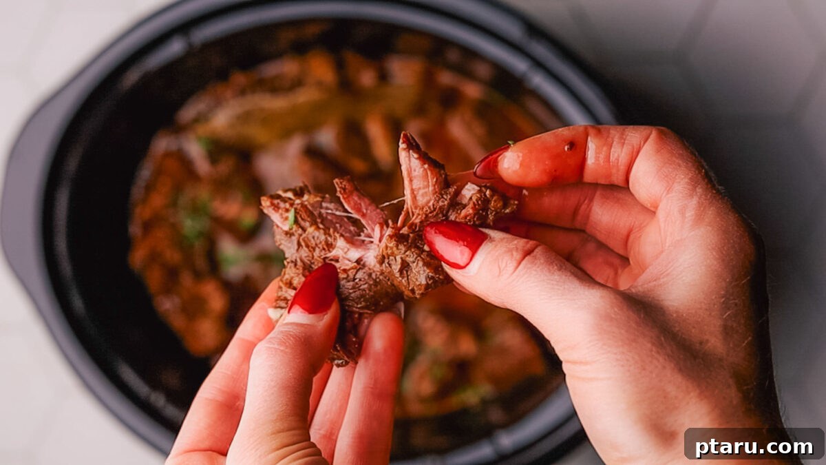 Melt-in-Your-Mouth Slow Cooker Beef Tips and Gravy 9 Close-up of Crockpot Beef Tips with gravy, ready to be served over a side dish, garnished with parsley.