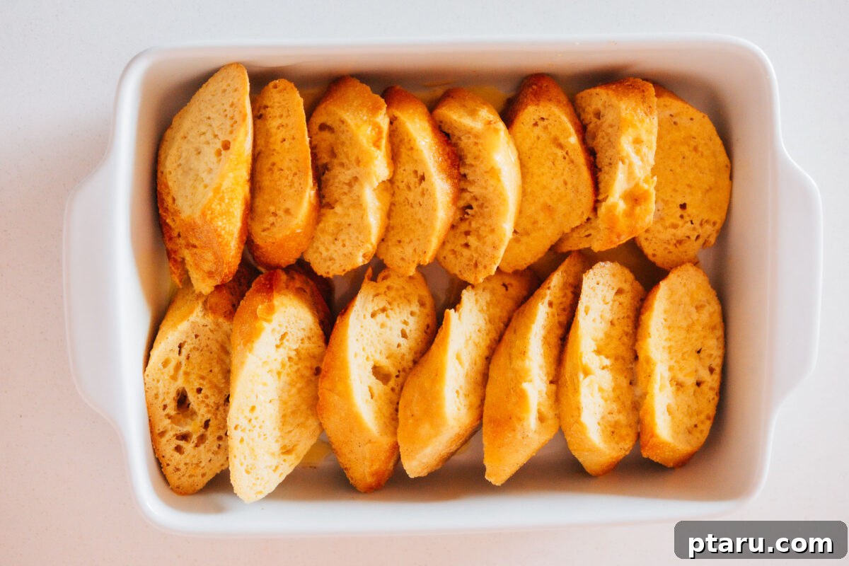 Sunrise French Toast Casserole 5 Image showing bread slices dipped in custard and arranged in a baking dish.