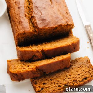 Artfully arranged slices of moist Pumpkin Banana Bread on a plate, showcasing its tender crumb, rich texture, and inviting autumnal appeal.