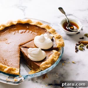 A perfectly baked, golden-brown Homemade Pumpkin Pie, generously sliced and artfully presented, a quintessential classic fall dessert.