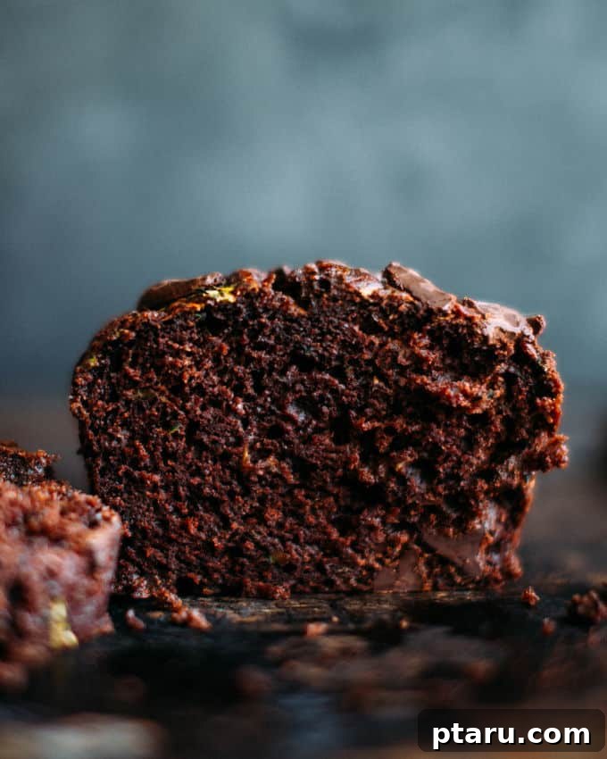 Moist Chocolate Zucchini Delight 2 A beautifully baked loaf of chocolate zucchini bread, rich with dark chocolate chunks and a golden-brown crust.