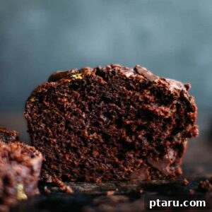 Moist Chocolate Zucchini Delight 7 Close-up of a chocolate zucchini muffin, cut in half to show the moist interior and generous chocolate chunks.