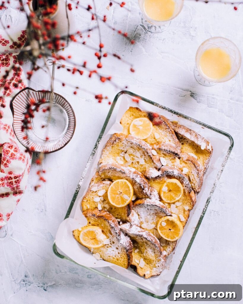 Provençal Orange Bake 2 Orange French Toast Casserole (overnight) baked in a 9x13 pan with a delicate dusting of powdered sugar, ready to be served.