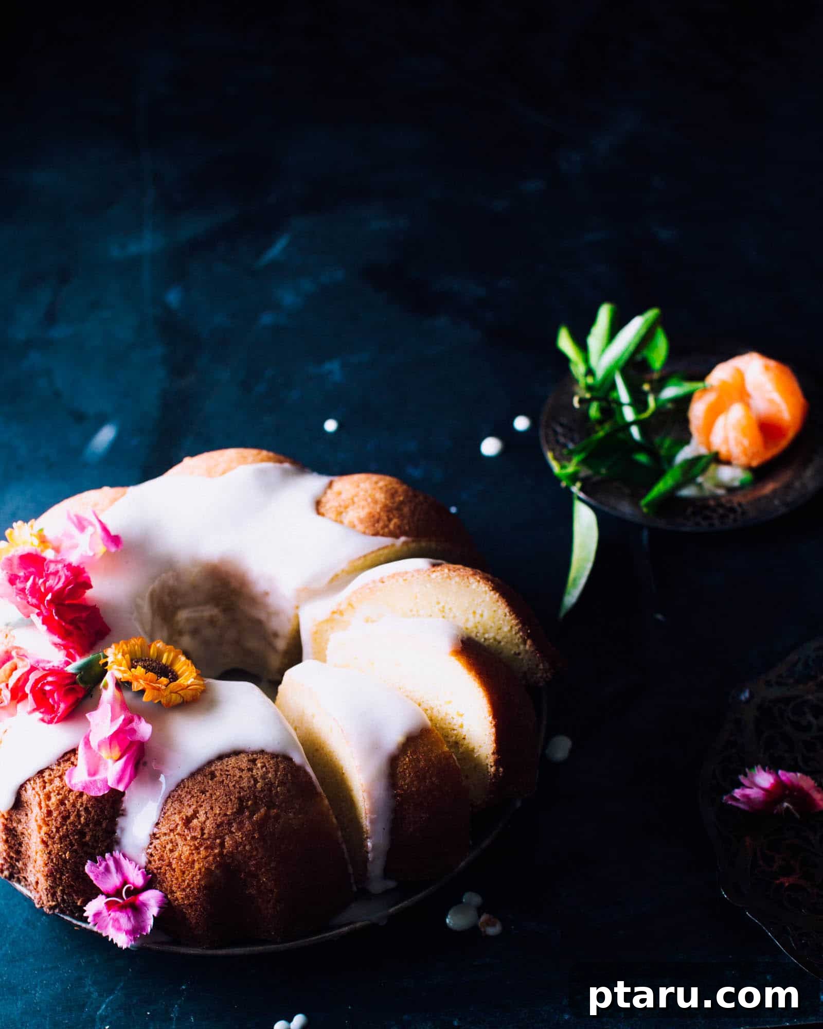 Zesty Orange Pound Cake with Citrus Glaze 2 Vibrant orange pound cake with a generous orange icing drizzle and fresh floral garnish.