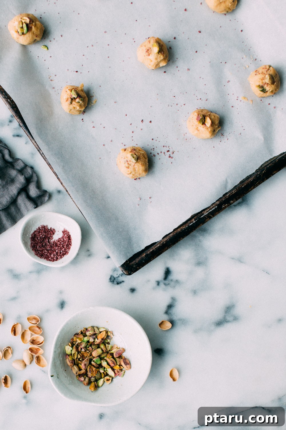 Zesty Lemon Pistachio White Chocolate Delights 4 A single Lemon Pistachio White Chocolate Cookie held delicately, revealing its chewy texture, glistening white chocolate chunks, and vibrant green pistachios.