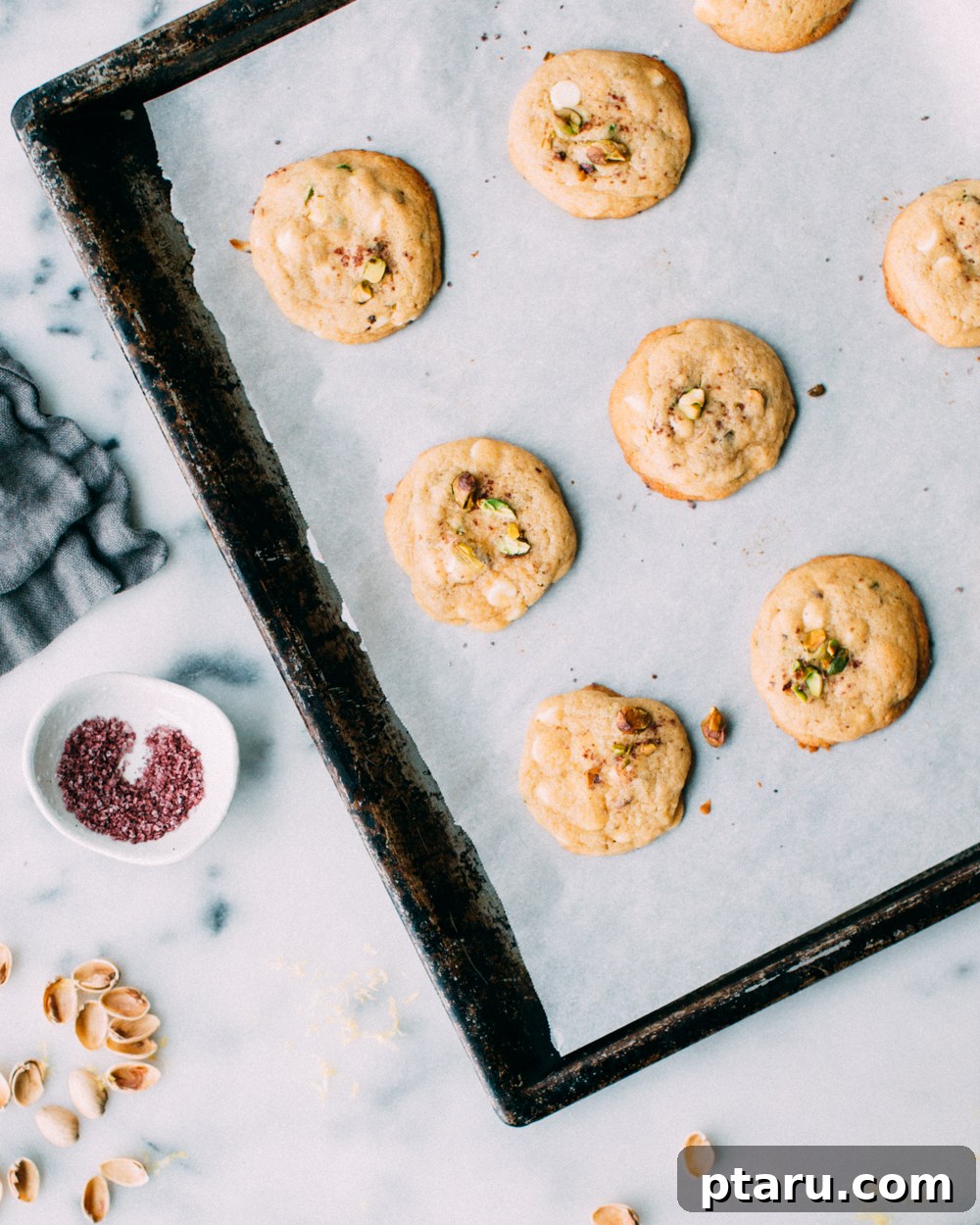 Zesty Lemon Pistachio White Chocolate Delights 5 A close-up of a Lemon Pistachio White Chocolate Cookie, showing the texture, melted white chocolate, and crushed pistachios, ready to be enjoyed.