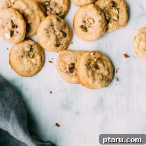 Zesty Lemon Pistachio White Chocolate Delights 7 A perfectly baked Lemon Pistachio White Chocolate Cookie with a bite taken out, revealing its moist interior and generous fillings.