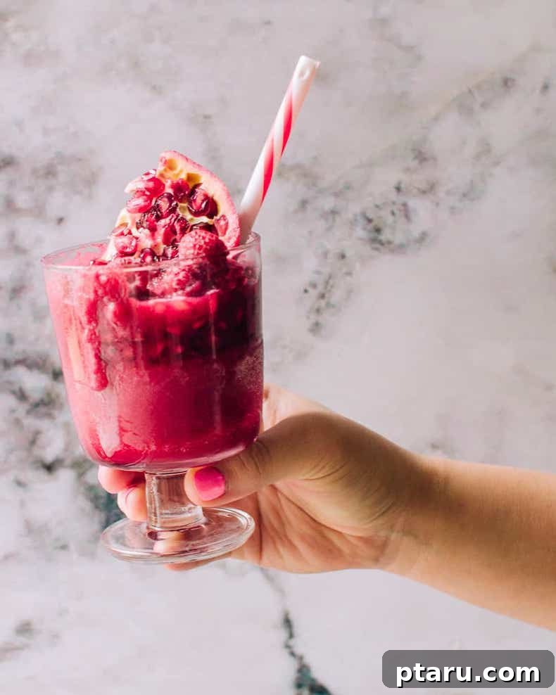 A vibrant beet smoothie, showcasing its deep red hue, served in a glass with a red striped straw, indicating a healthy and flavorful drink.
