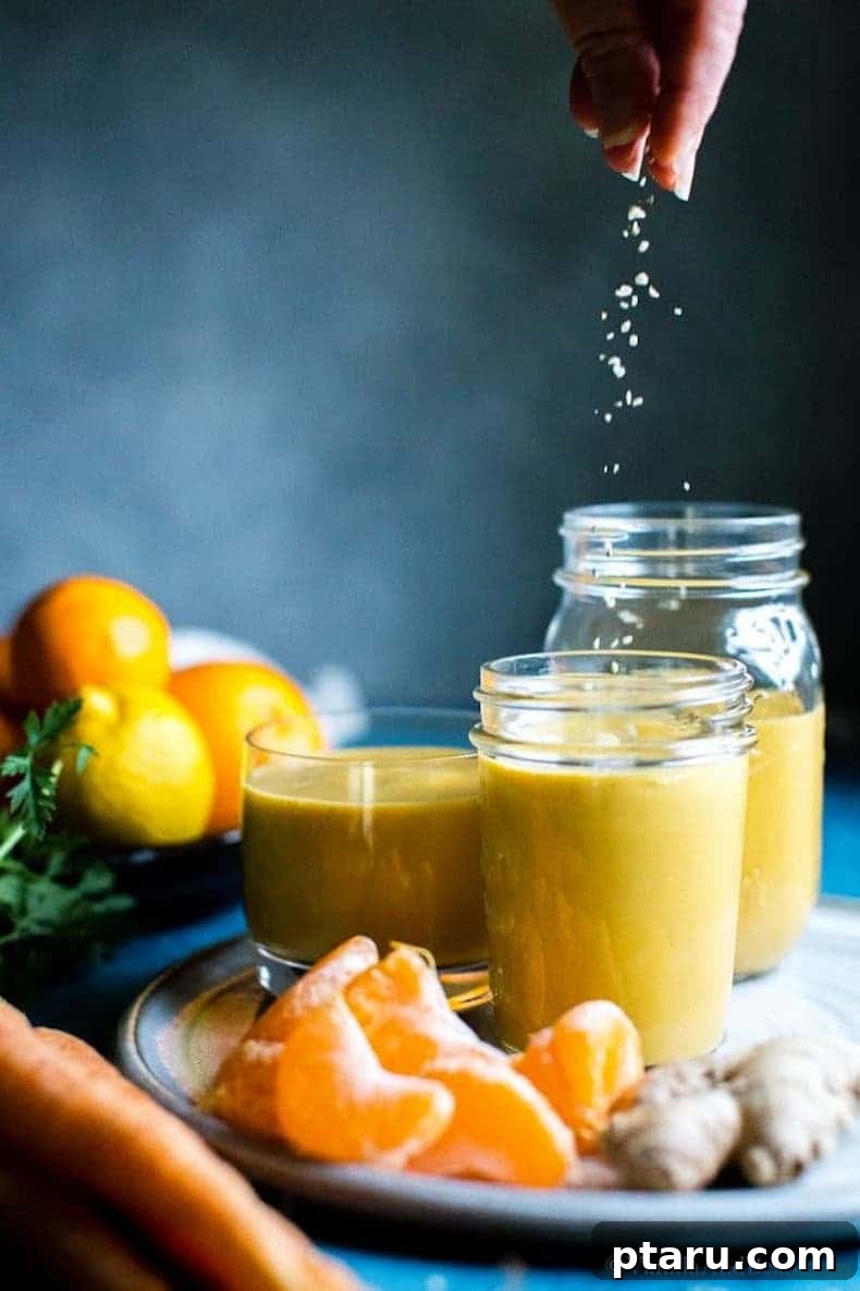 25+ Game-Changing Healthy Smoothie Recipes 12 A hand squeezing a fresh orange into a smoothie blender, highlighting the addition of citrus for a bright and immunity-boosting drink.