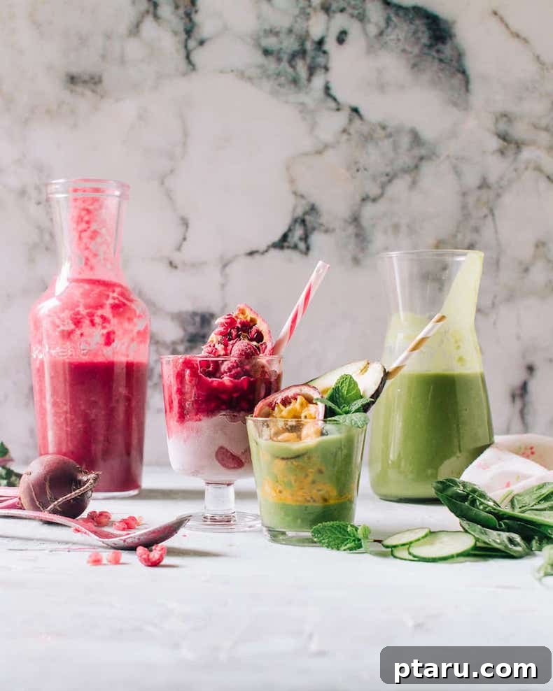 A jar and a glass filled with a refreshing green avocado smoothie, alongside a pink smoothie, set on a table, highlighting healthy beverage options.