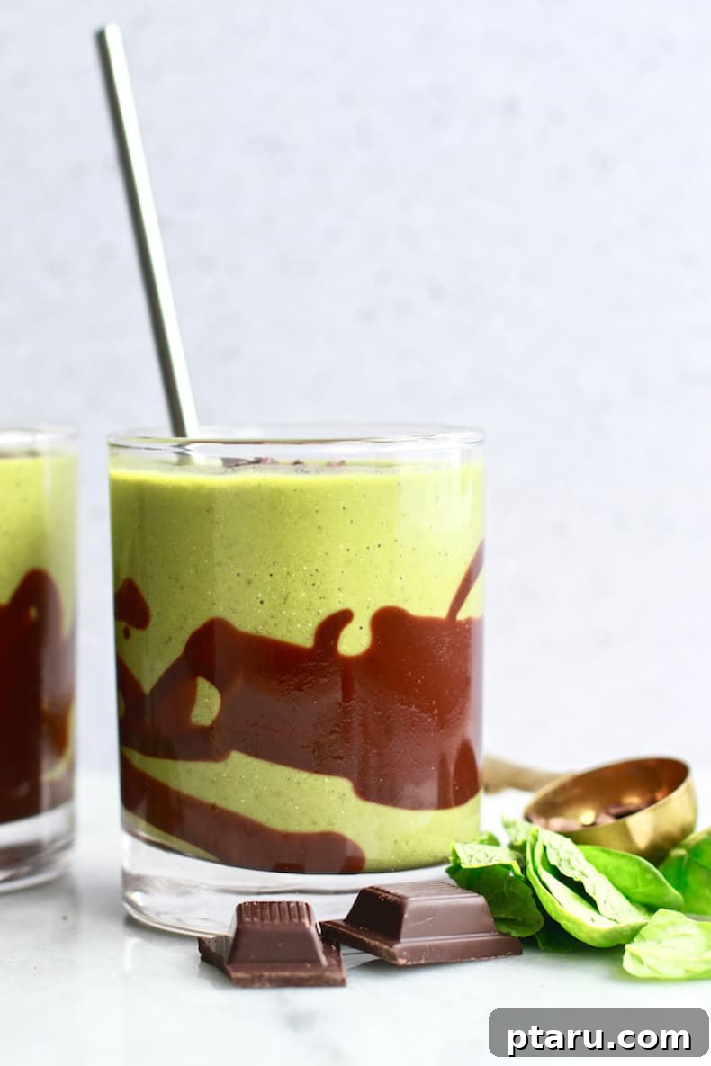 A luscious green smoothie, elegantly drizzled with chocolate, combining healthy spinach and banana with an indulgent mint chocolate flavor.
