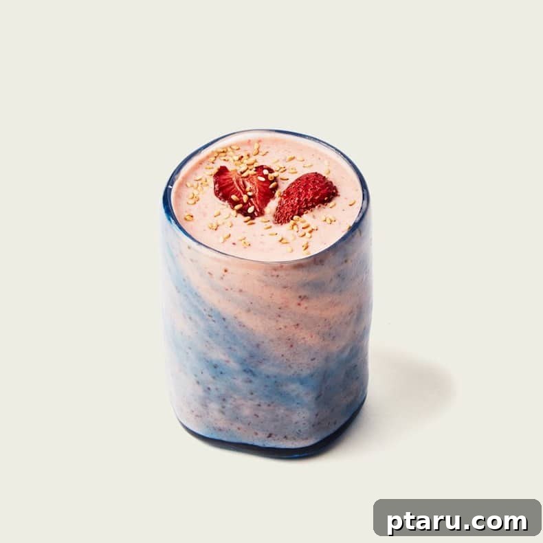 25+ Game-Changing Healthy Smoothie Recipes 9 A visually appealing strawberry smoothie in a glass, with a unique blue swirl design, suggesting an exotic or unconventional blend of ingredients.