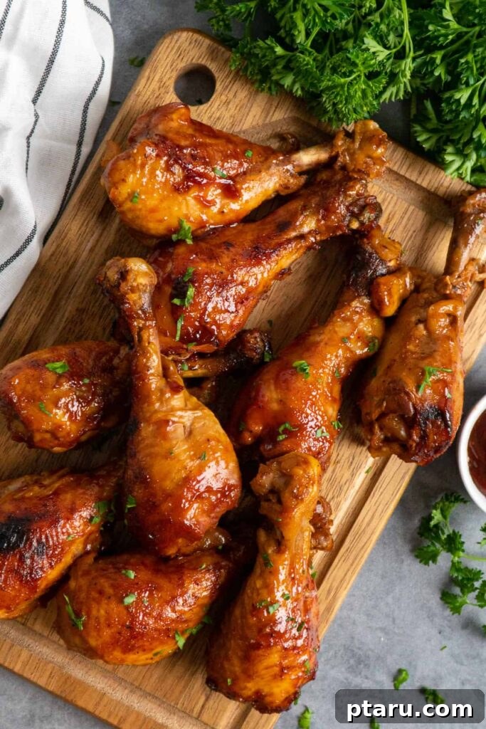 41 Succulent Chicken Drumstick Recipes You Can Make Effortlessly 17 Tender Slow Cooker BBQ Chicken Drumsticks arranged on a rustic wooden cutting board.
