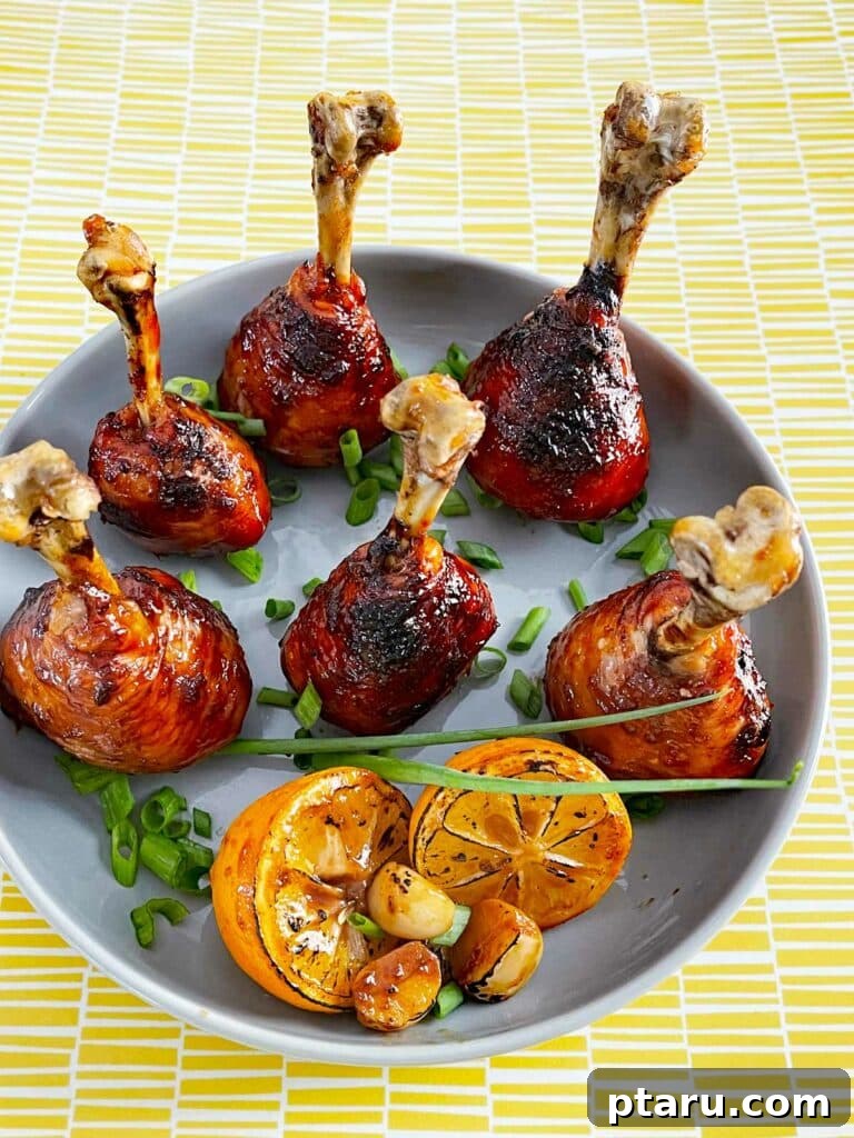 41 Succulent Chicken Drumstick Recipes You Can Make Effortlessly 23 Lollipop Chicken Drumsticks served on a plate with fresh lime wedges and scallions.