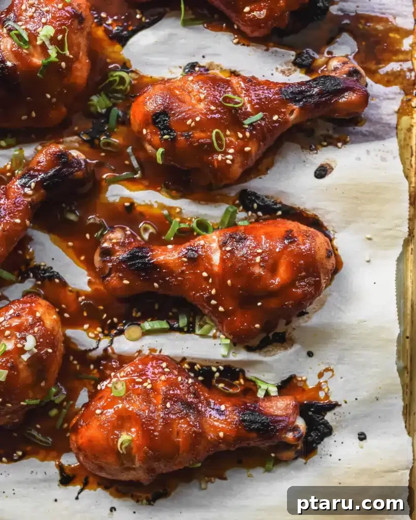 41 Succulent Chicken Drumstick Recipes You Can Make Effortlessly 8 Spicy Gochujang Chicken Drumsticks with a vibrant glaze on a sheet pan.