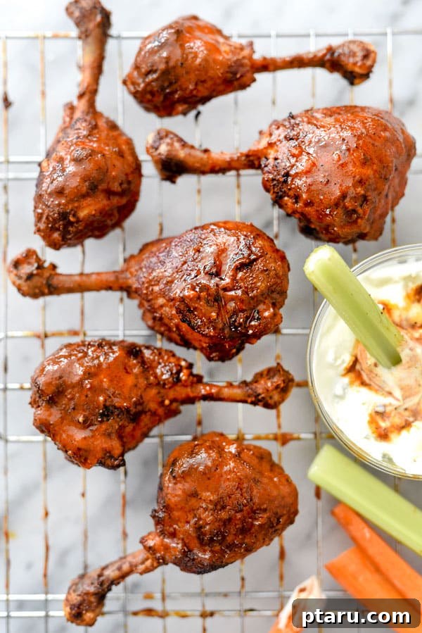 41 Succulent Chicken Drumstick Recipes You Can Make Effortlessly 10 Spicy Buffalo Chicken Drumsticks on a wire rack with a side of blue cheese dip.